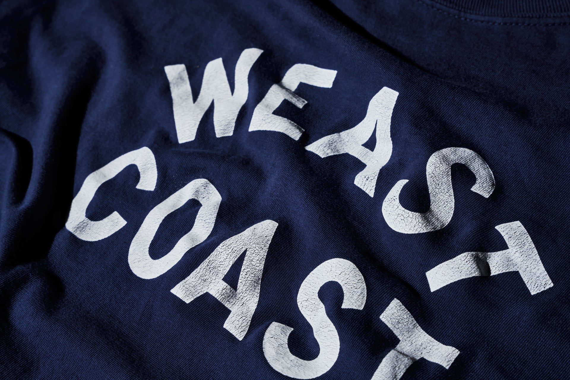 detail of Navy t-shirt with crackle print weast coast arched letters