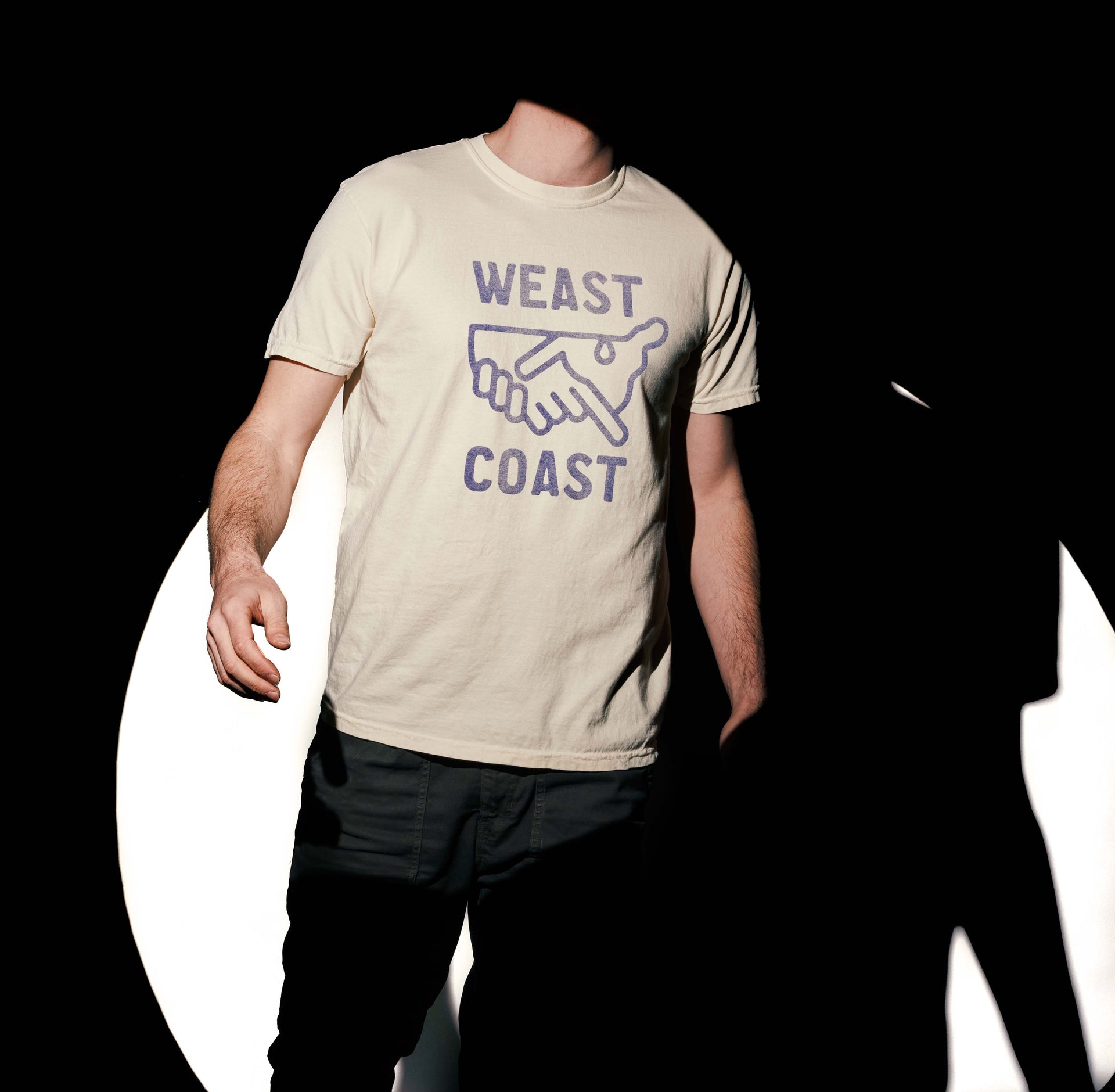 Model wearing cream t-shirt in spotlight